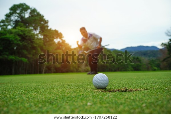Blurred golfer playing golf in the evening\
golf course, on sun set evening time. Man playing golf on a golf\
course in the sun.                              \
