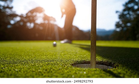 Blurred golfers are playing golf in the evening golf course golf backglound. Golfer hitting golf ball.                                - Powered by Shutterstock