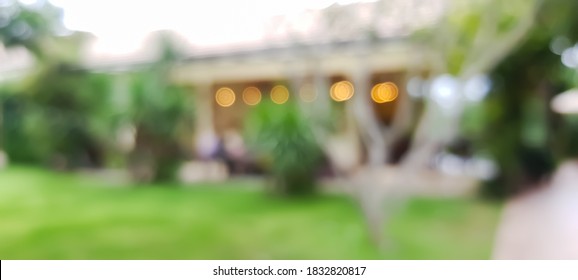 Blurred grassy backyard outside cafe and resturant inside the resort with bokeh lights effect background.