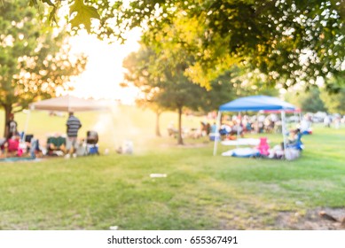 Blurred Group Of African American Friend, Family Members Enjoy Barbecue On Camping In Urban Park In Houston, Texas, US At Sunset. BBQ Grill With Meat Skewers Smoke. Outdoor Party And Picnic Concept.