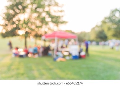 Blurred Group Of African American Friend, Family Members Enjoy Free Outdoor Music Festival, Open-air Concert Held In Public Park At Downtown Houston. Audience Sits On The Chairs, Grass With Open Tent.