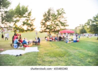 Blurred Group Of African American Friend, Family Members Enjoy Free Outdoor Music Festival, Open-air Concert Held In Public Park At Downtown Houston. Audience Sits On The Chairs, Grass With Open Tent.