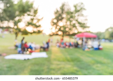 Blurred Group Of African American Friend, Family Members Enjoy Free Outdoor Music Festival, Open-air Concert Held In Public Park At Downtown Houston. Audience Sits On The Chairs, Grass With Open Tent.