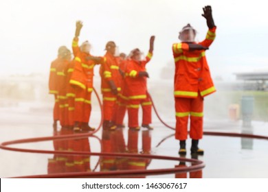 Blurred Group Of Firefighters Made A Gesture To Signal The Team During Training, Fire In The Industrial Factory, Rescue Teamwork Concept.