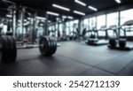 blurred gym background, sports fitness room with treadmills and exercise equipment in defocus, and text copy space