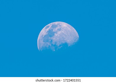 Blurred half moon on blue sky and clear clouds on daytime