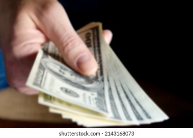 Blurred. Hands passing money under table corruption bribery