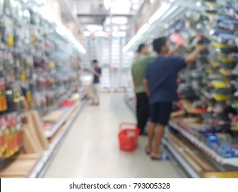 Blurred Hardware Store With Shelf , Aisle And Customers Buying Tools.