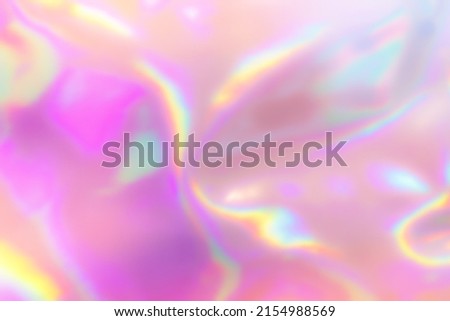 Blurred Holography abstract background in blue pink colors. Holographic color wrinkled pearlescent foil. Holographic iridescent rainbow fabric abstract background.