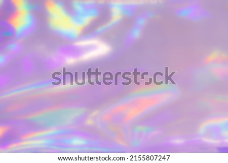 Blurred Holography abstract background. Holographic  wrinkled pearlescent foil. Holographic iridescent rainbow fabric abstract background.