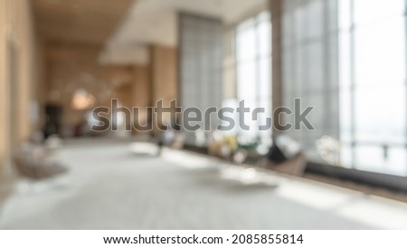 Blurred hotel or office building lobby blur background interior view toward reception hall, modern luxury white room space with blurry corridor and building glass wall window