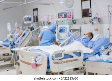 Blurred ICU Room In A Hospital With Medical Equipments And Patient. 