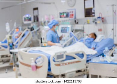 Blurred ICU Room In A Hospital With Medical Equipments And Patient. 