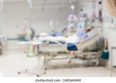 Blurred ICU Room In A Hospital With Medical Equipments And Patient.