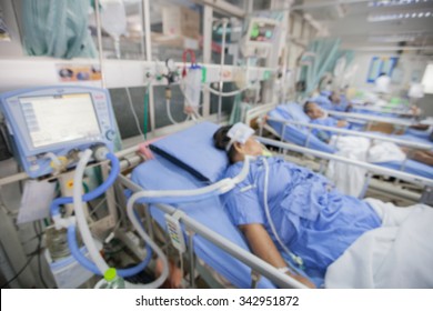 Blurred ICU Room In A Hospital With Medical Equipments And Patient.