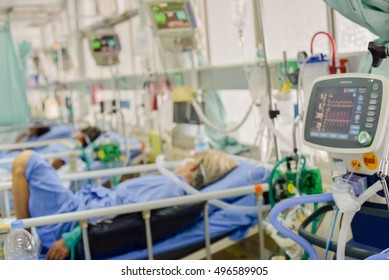 Blurred ICU Room In A Hospital With Medical Equipments And Patient.