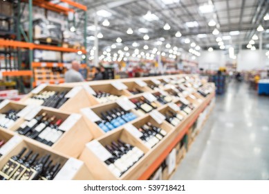 Blurred Image Aisle Of Bottles In Wine Section Of Modern Distribution Warehouse With Customers Choosing Wine. Inventory, Logistic, Business, Wholesale, Export Concept. Beverage Alcohol Background.