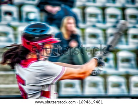 Blurred image of anonymous exciting female athlete successfully strikes a home run during a baseball game