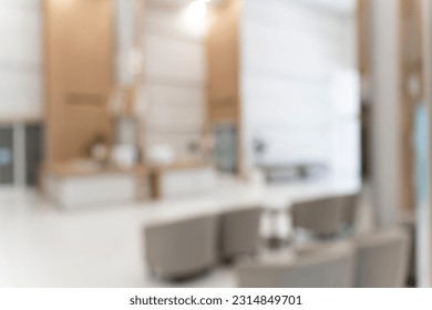 Blurred image background of corridor in hospital or clinic, counter information and sofa in waiting area near front of the examination room, nobody in image