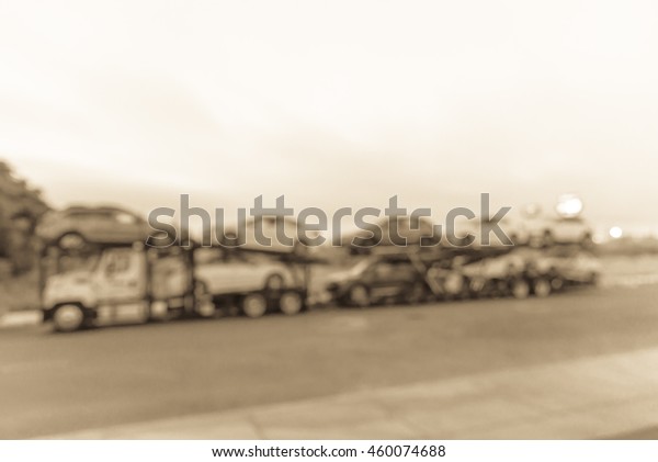 Blurred image big car carrier truck of new cars for
batch delivery to dealership. Full load transport truck of new
vehicles on country road. Automotive industry abstract
background.Vintage filter
look