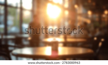 A blurred image of a cafe interior with warm sunlight streaming through the windows, featuring tables and a soft, inviting atmosphere.
