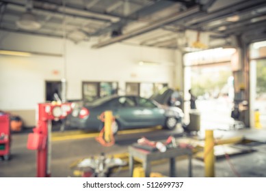 Blurred Image Of Car In Auto Shop. Defocused Background Of Modern Repair Shop. Small Car Oil Change Service Station At Little Rock, Arkansas, US. Repair Shop With Working Auto Mechanic. Vintage Filter