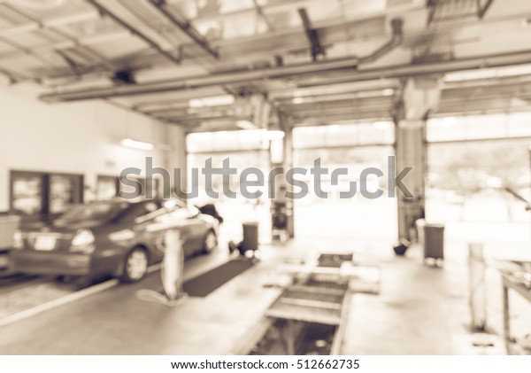 Blurred image of car in auto shop. Defocused\
background of modern repair shop. Small car oil change service\
station at Little Rock, Arkansas, US. Repair shop with working auto\
mechanic. Vintage\
filter