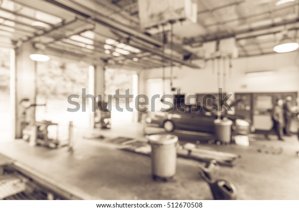 Blurred image of car in auto shop. Defocused\
background of modern repair shop. Small car oil change service\
station at Little Rock, Arkansas, US. Repair shop with working auto\
mechanic. Vintage\
filter