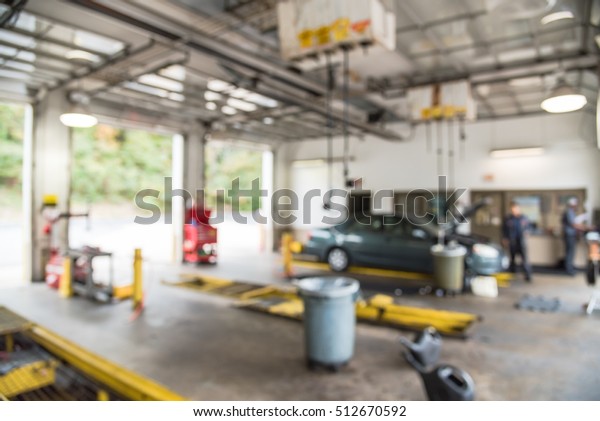 Blurred image of car in auto shop. Defocused\
background of modern repair shop. Small car oil change service\
station at Little Rock, Arkansas, US. Interior of car repair shop\
with working auto\
mechanic