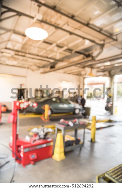 Blurred image of car in auto shop. Defocused\
background of modern repair shop. Small car oil change service\
station at Little Rock, Arkansas, US. Interior of car repair shop\
with working auto\
mechanic