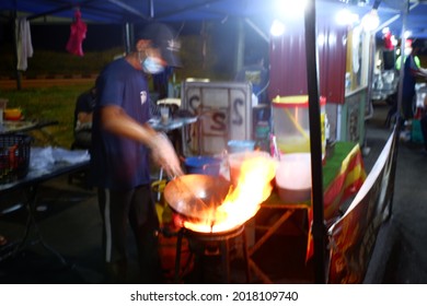 Blurred Image. The Chef Was Preparing Food At The Hawker Stall Using A Large Fire From A Gas Stove.