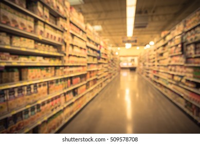 Blurred image of condiment, soup, pasta and canned vegetable aisle in store. Wide perspective view aisle, shelves with variety of products, defocused blurry background with bokeh light. Vintage filter - Shutterstock ID 509578708