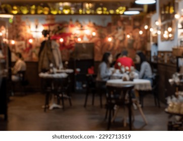 Blurred image of cozy cafe with color illumination and silhouettes of visitors at the tables - Powered by Shutterstock