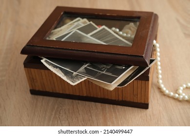 blurred image, dear to heart memorabilia in an old wooden box, stack of retro photos, vintage photographs of 1940, concept of family tree, genealogy, childhood memories, home archive