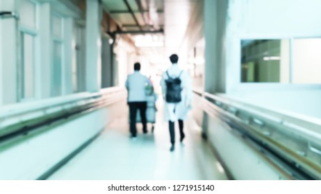 Blurred Image Of Doctor And Nurses Walking On The Path In The Hospital Building.