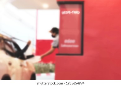 Blurred Image Drive-thru Fast-food Hamburger Shops On The Outside Side Of The Store And A Parking Lot Is Waiting To Receive Food The Salesperson Is Submitting The Product To The Buyer Inside The Car