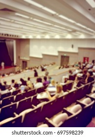 Blurred image of education people and business people sitting in conference room for profession seminar and the speaker is presenting new technology and idea sharing via screen projector. - Shutterstock ID 697598239