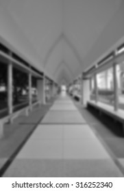 blurred image of empty corridor between garden and building (monochrome background)