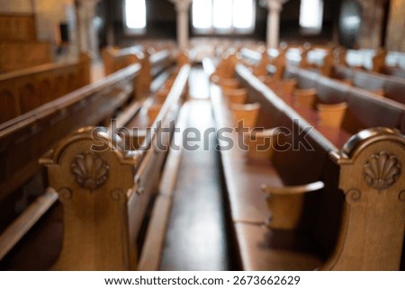Blurred image of empty pews inside protestant church in Europe. Wide angle view, natural window light, no people