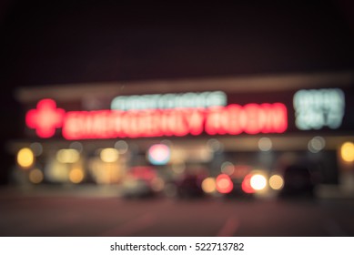 Blurred Image Exterior Emergency Room With Neon Led Sign Illuminated At Night In Houston, Texas, US. Facade Of Emergency Department Neon Shining Signboard. Healthcare Service Concept. Vintage Filter.