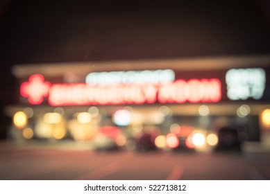 Blurred Image Exterior Emergency Room With Neon Led Sign Illuminated At Night In Houston, Texas, US. Facade Of Emergency Department Neon Shining Signboard. Healthcare Service Concept. Vintage Filter.