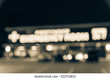 Blurred Image Exterior Emergency Room With Neon Led Sign Illuminated At Night In Houston, Texas, US. Facade Of Emergency Department Neon Shining Signboard. Healthcare Service Concept. Vintage Filter.