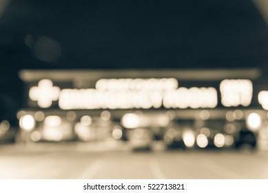 Blurred Image Exterior Emergency Room With Neon Led Sign Illuminated At Night In Houston, Texas, US. Facade Of Emergency Department Neon Shining Signboard. Healthcare Service Concept. Vintage Filter.