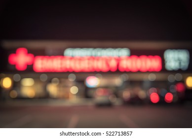 Blurred Image Exterior Emergency Room With Neon Led Sign Illuminated At Night In Houston, Texas, US. Facade Of Emergency Department Neon Shining Signboard. Healthcare Service Concept. Vintage Filter.