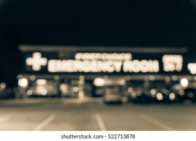 Blurred Image Exterior Emergency Room With Neon Led Sign Illuminated At Night In Houston, Texas, US. Facade Of Emergency Department Neon Shining Signboard. Healthcare Service Concept. Vintage Filter.