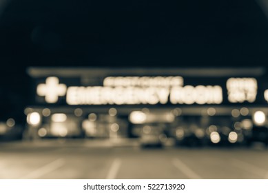 Blurred Image Exterior Emergency Room With Neon Led Sign Illuminated At Night In Houston, Texas, US. Facade Of Emergency Department Neon Shining Signboard. Healthcare Service Concept. Vintage Filter.