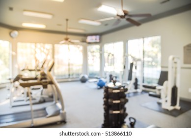 Blurred Image Of Fitness Center With Cardio Machines And Weight, Strength Training Equipment. Empty Gym Facility Service Room In Apartment Building Complex At Houston, Texas, US. Active Lifestyle.