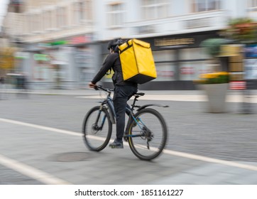 Blurred image of a food delivery courier delivering food. Motion blur defocused image