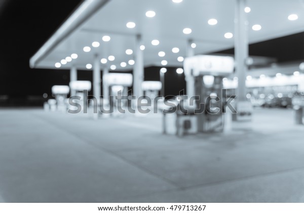 Blurred image of gas station at night. Defocused,
out of focus gas station and convenience store in evening twilight.
Abstract blur petrol station background with copy space. Vintage
filter look.