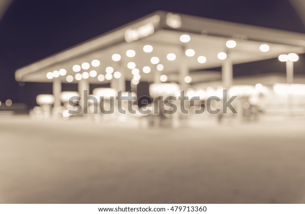 Blurred image of gas station at night. Defocused,\
out of focus gas station and convenience store in evening twilight.\
Abstract blur petrol station background with copy space. Vintage\
filter look.